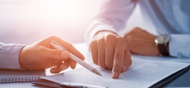 Business people negotiating a contract. Human hands working with documents at desk and signing contract.