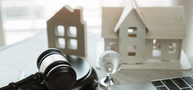 Judge gavel and house model on Notebook computer, Online Auction for Real Estate concept. Ideas for housing business judgment by E-commerce online goods services digital technology held over internet.